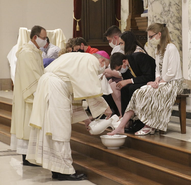 Bishop washing the feet of a young girl.
